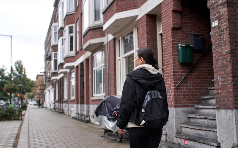 Jonge vrouw loopt in Den Haag in de regen