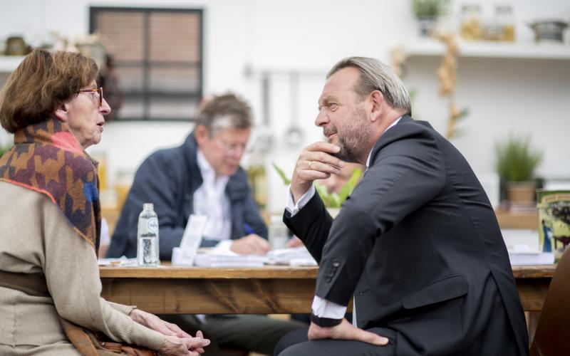 Reinier van Zutphen, de Nationale ombudsman, in gesprek met een senior vrouw.