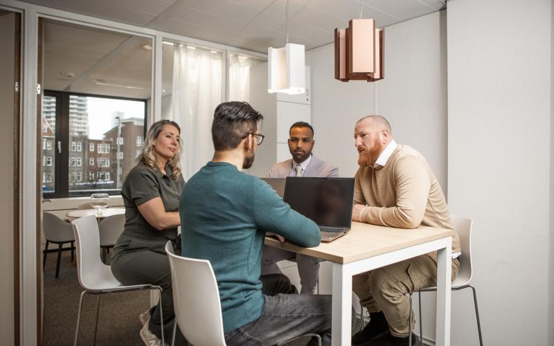 Groep collega's praten aan tafel op kantoor