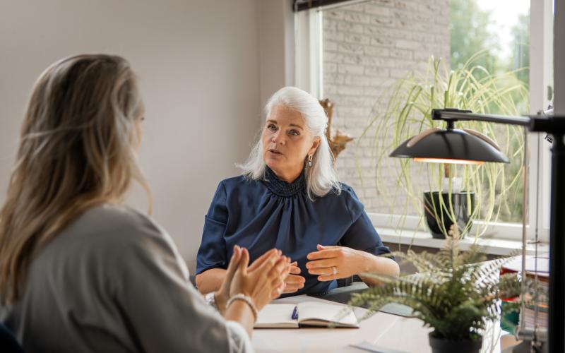 Twee vrouwelijke collega's op kantoor met elkaar in gesprek