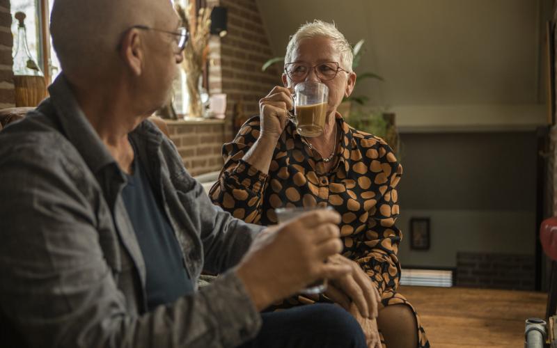 Man en vrouw op de bank thuis met thee 