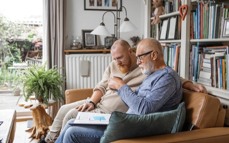 Vader en zoon thuis op de bank met een order op schoot