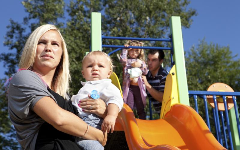 Ouders met kinderen in speeltuintje