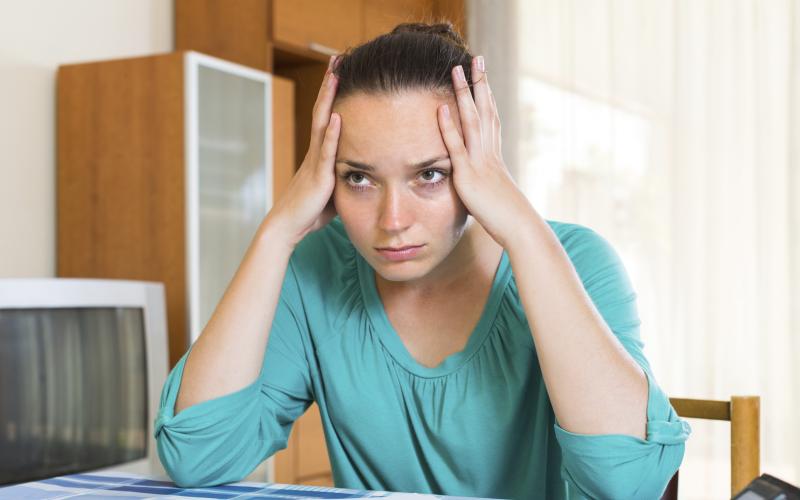 Vrouw heeft haar handen onder haar hoofd en staart voor zich uit