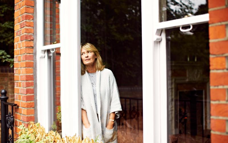 Vrouw staat bij het raam en kijkt naar buiten