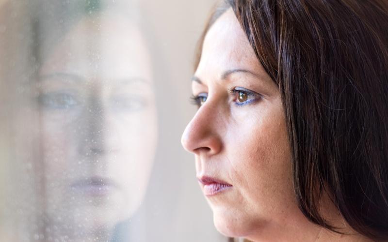 Foto van een vrouw die uit het raam kijkt