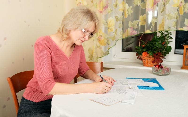 Vrouw met documenten aan tafel