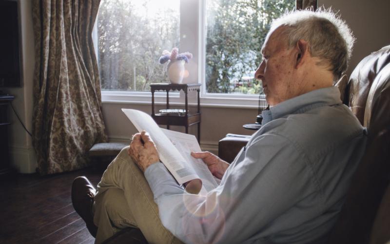 Senior man leest een boekje