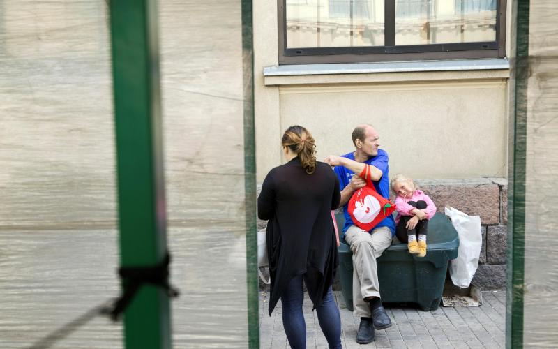 Een man en een vrouw met hun dochter op straat