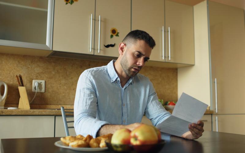 Man leest brief in de keuken