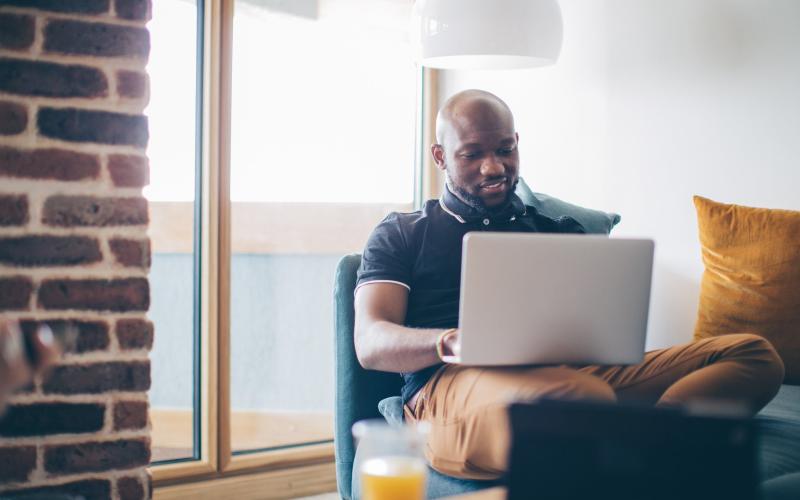 Man met laptop op schoot