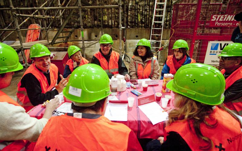 Mannen en vrouwen in een bouwvergadering