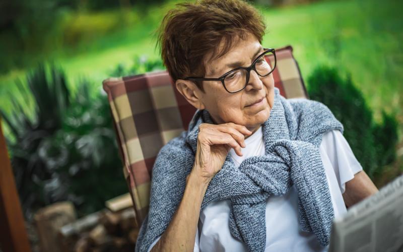 Vrouw leest krant in de tuin