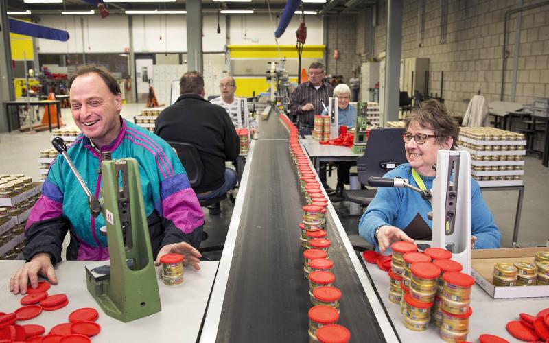 Een sociale werkplaats, twee mensen lachen tijdens het werk