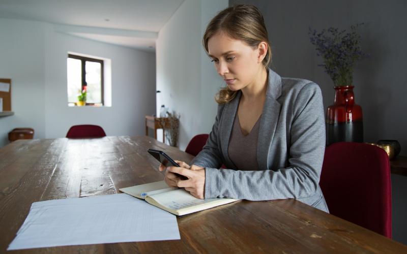 Vrouw aan tafel met mobiel