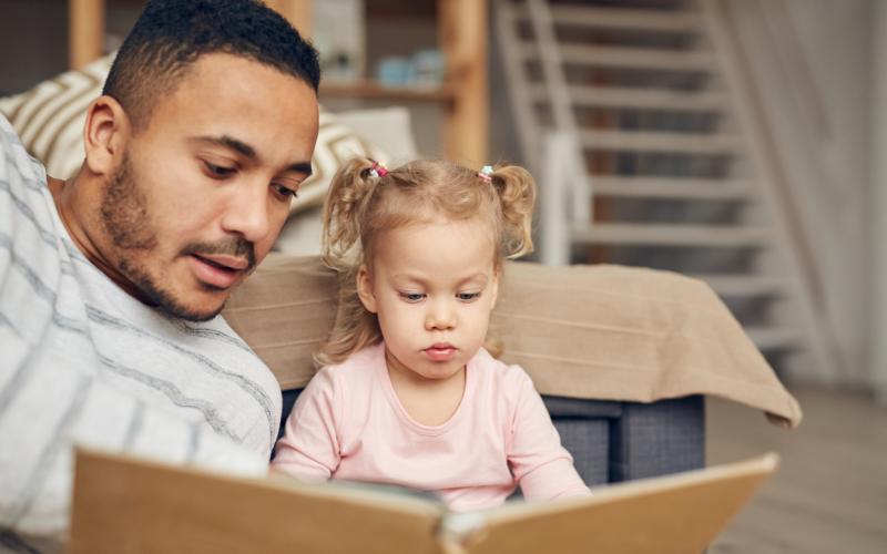 Vader leest boek met dochter