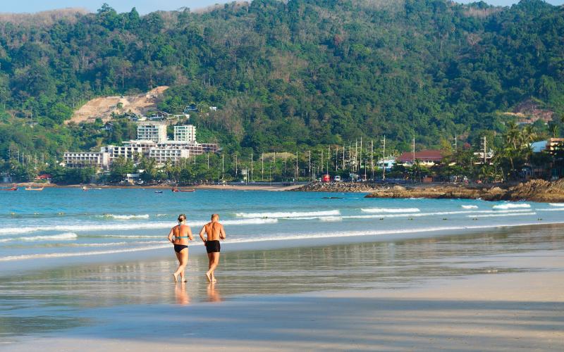 Man en vrouw rennen over strand