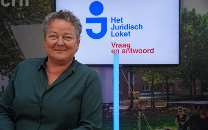 Vrouw (Anneke van Kesteren) met kort grijs haar, draagt donkere kleur blouse