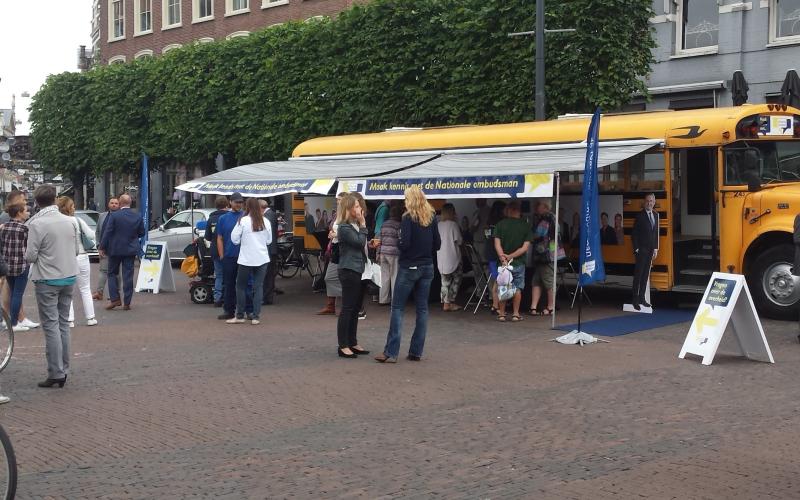 Foto van de gele Ombudsbus op de markt in de provincie Drenthe