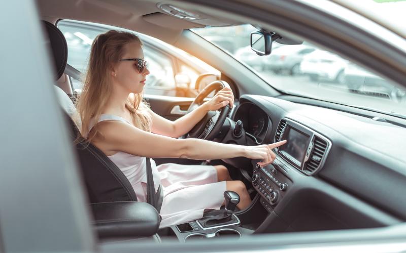 Vrouw in auto toetst in op boordcomputer