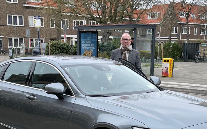 Taxichauffeur Dick Bakker naast zijn taxi