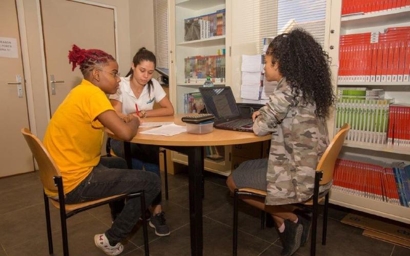 Drie studentes aan een tafel op school