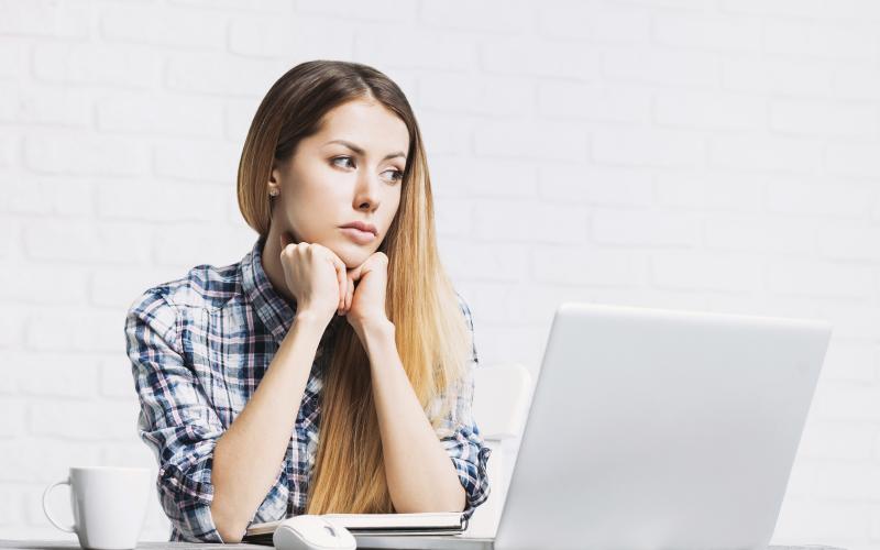 Jonge bezorgde vrouw met laptop