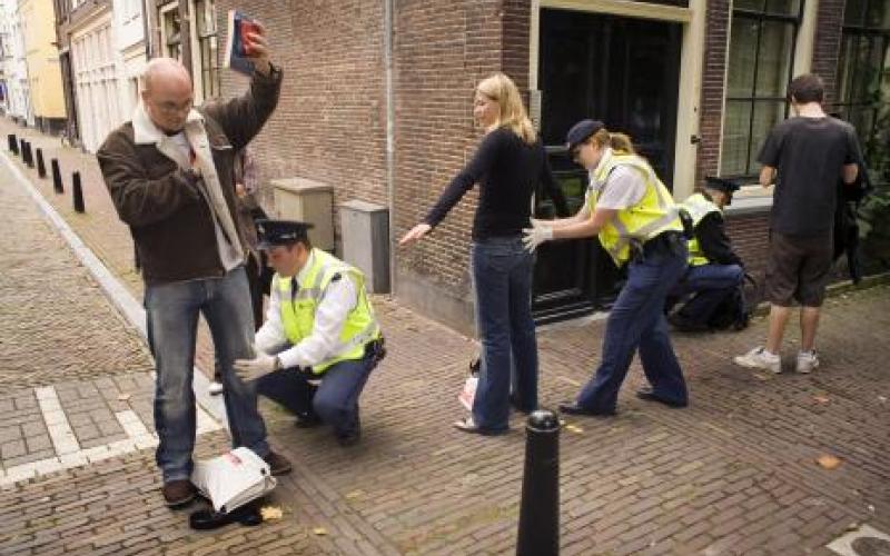 Foto van twee mensen die gefouilleerd worden door de politie