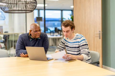 Twee mannen aan een bureau aan het overleggen