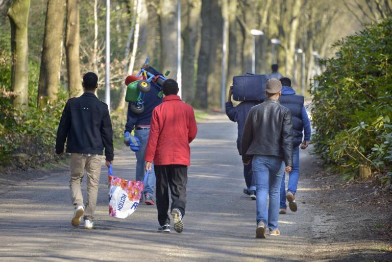 Mannen lopend op het terrein van een AZC