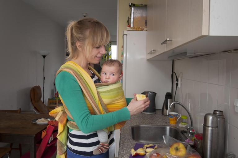 Moeder met baby in de keuken