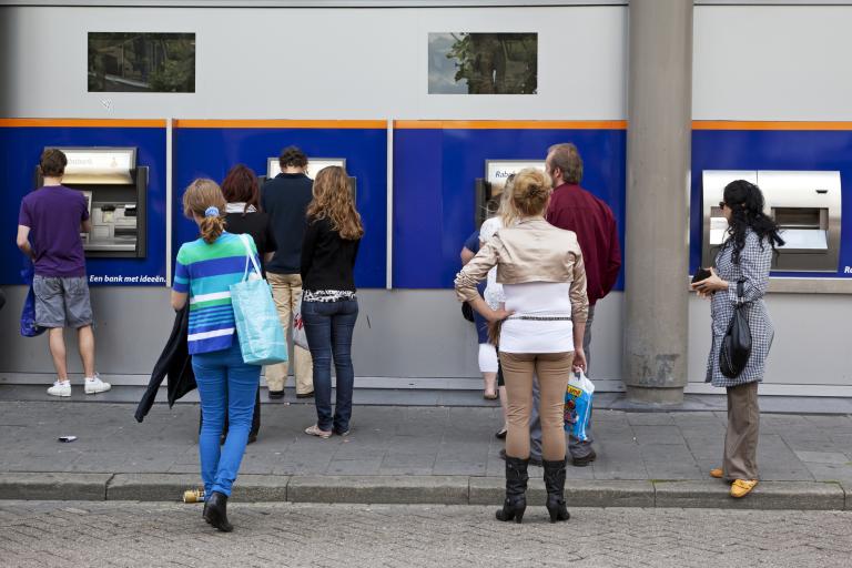 Mensen in de rij voor de pinautomaat